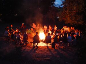 Kinder sitzen am Lagerfeuer