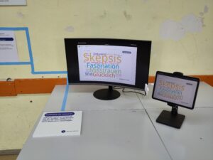 Hier ist ein Tablet und ein Bildschirm mit einer Wortwolke zur Frage "Welches Gefühl löst KI in dir aus?" abgebildet.