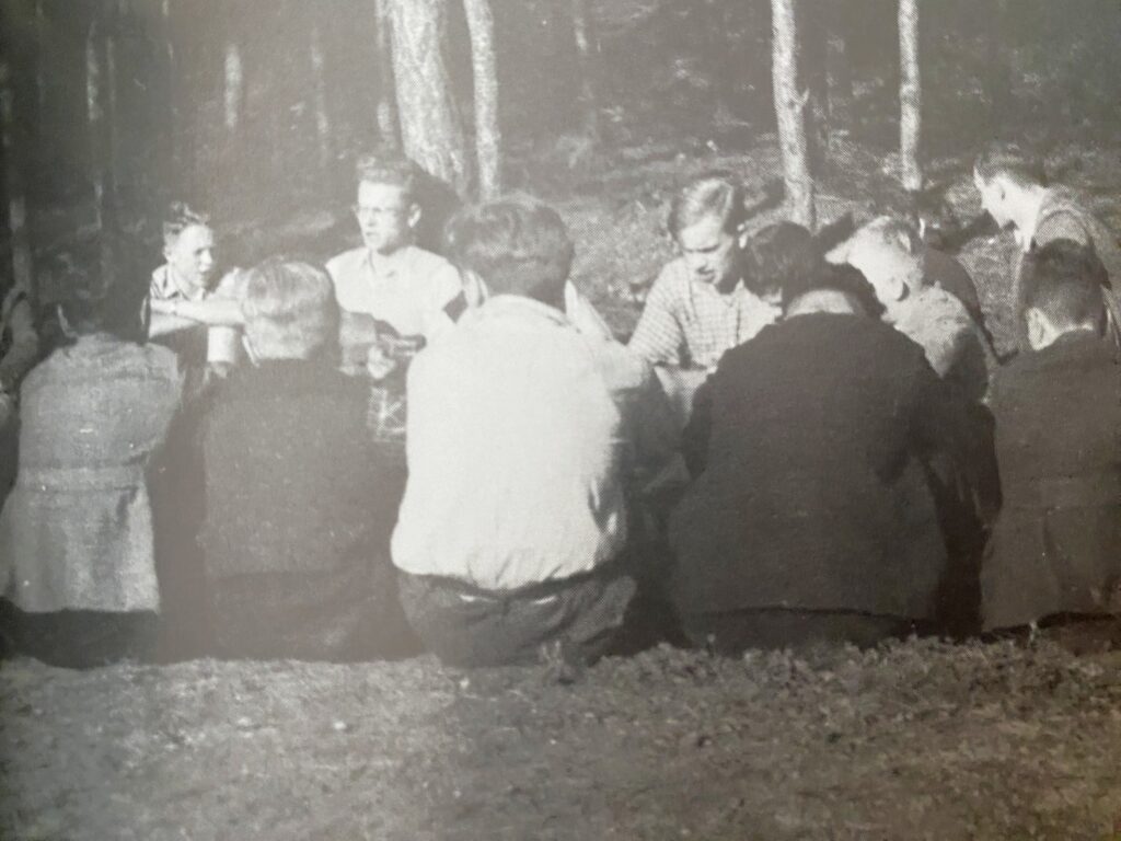 Das Bild zeigt ein Treffen der illegalen katholischen Jugendgruppe an einem Sonntag am Waldrand